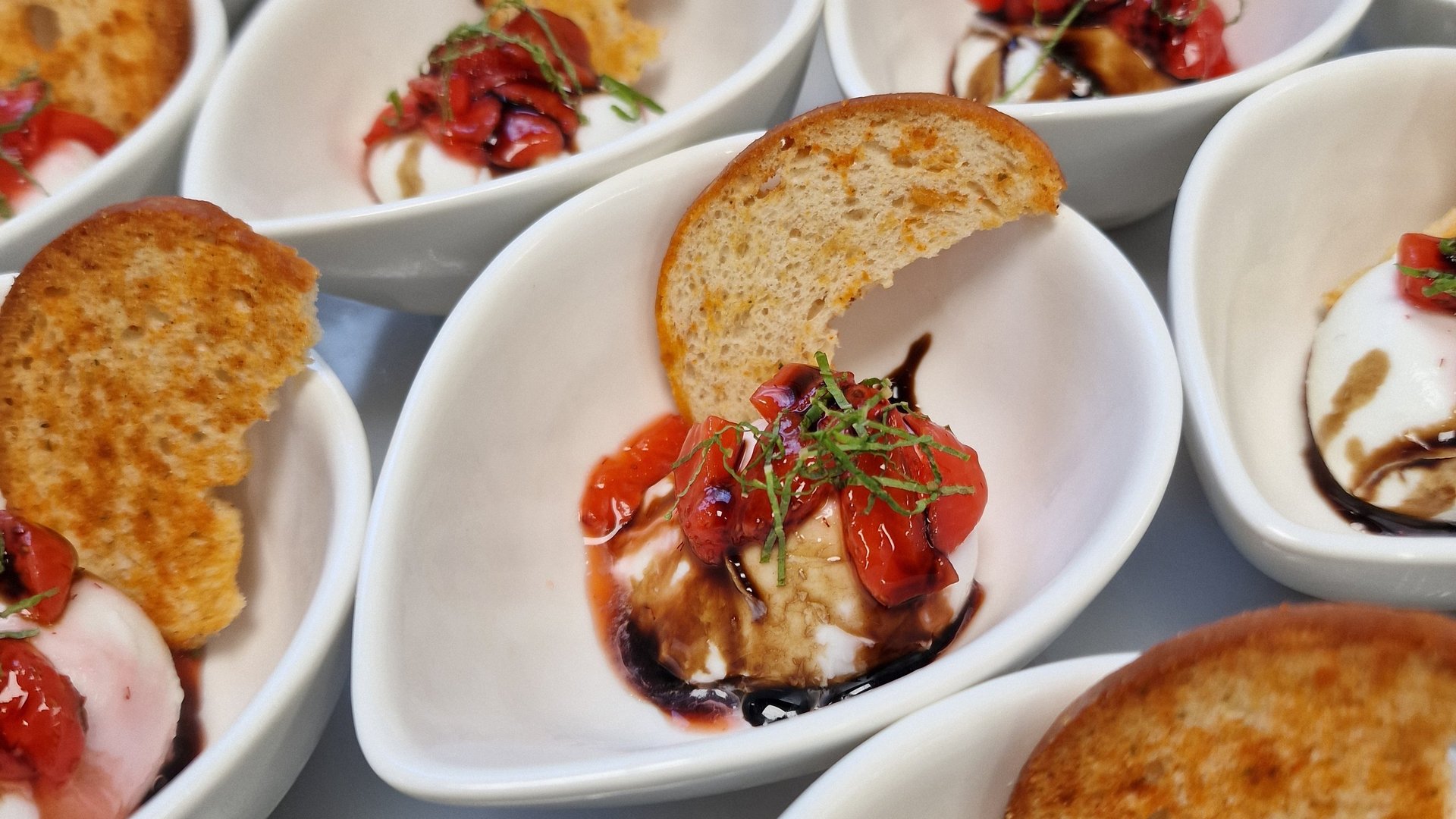 Ein reichhaltiges Frühstück mit knusprigem Toast, verschiedenen Marmeladen, frisch zubereiteten Eiern, Speck, Müsli, frischem Obst, einer Tasse Kaffee und einem Glas Saft